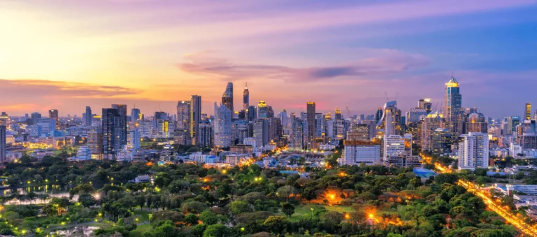 Colorful Bangkok sunset over skyscrapers and green parks, showcasing the Top 10 Must-Do Activities in Bangkok.
