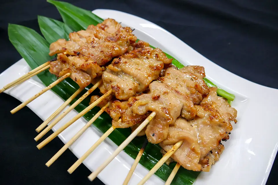 Top Bangkok Street Food: Moo Ping grilled pork skewers at Chatuchak Market, a popular Bangkok street food