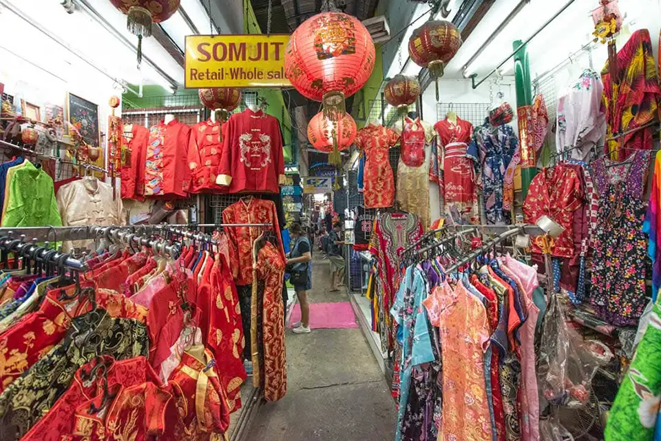 Colorful cheongsams and festive decor at Pratunam—Bangkok’s vibrant market scene on a budget.