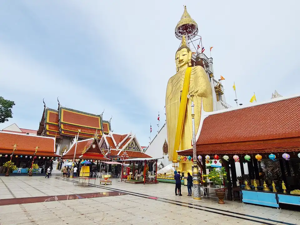 Wat Intharawihan's massive standing Buddha towers over the temple grounds, where visitors gather to admire the sight