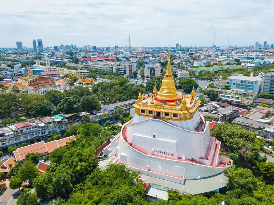 Wat Saket's gleaming golden stupa surrounded by trees in central Bangkok, offering panoramic city views without the hefty price tag