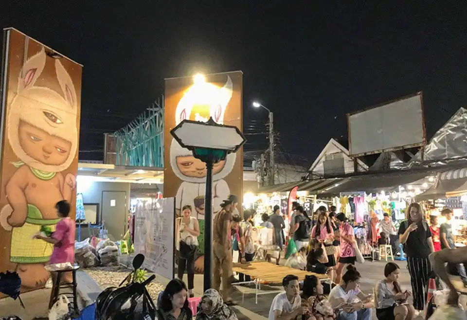 Lively scenes from Chatuchak’s night market—crowds, lights, and playful street art.