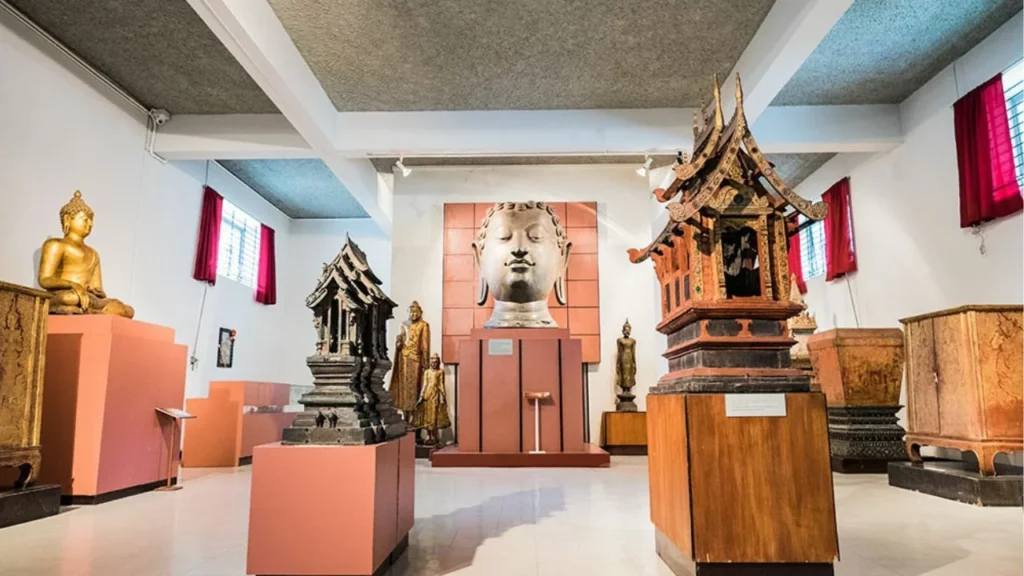 Chiang Mai Museums: Serene Buddha head and temple miniatures showcased in Chiang Mai National Museum’s cultural gallery.