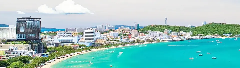 Pattaya photo spots: Aerial view of Jomtien Beach showing the curved coastline, crystal clear blue water with boats, and hotels lining the shore
