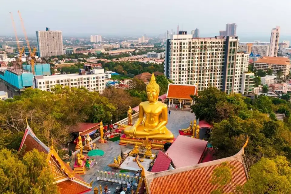 Aerial view of Big Buddha Pattaya temple with its massive golden Buddha statue overlooking the city skyline and surrounding buildings