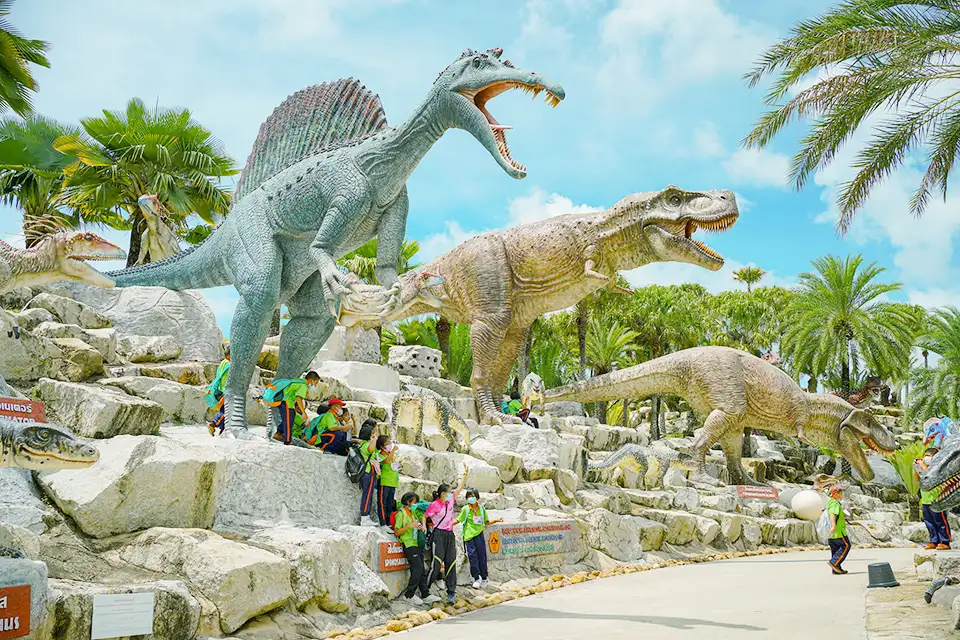 Family Trip in Pattaya: Educational dinosaur attraction at Nong Nooch where children can learn about prehistoric creatures among tropical palm trees