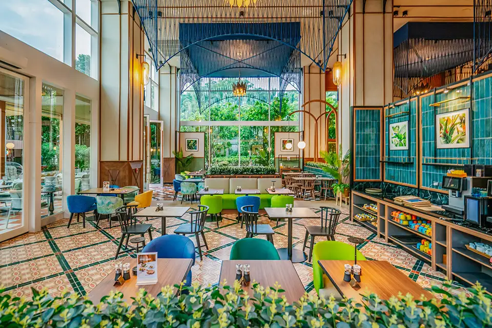 Family Trip in Pattaya: Modern restaurant interior at The Collective showcasing playful blue and green seating, geometric patterns, and abundant natural light