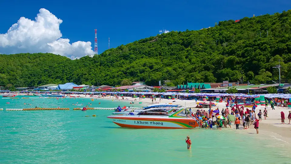 Family Trip in Pattaya: Popular beach at Koh Larn packed with day-trippers, speedboats, and beach activities on a sunny day