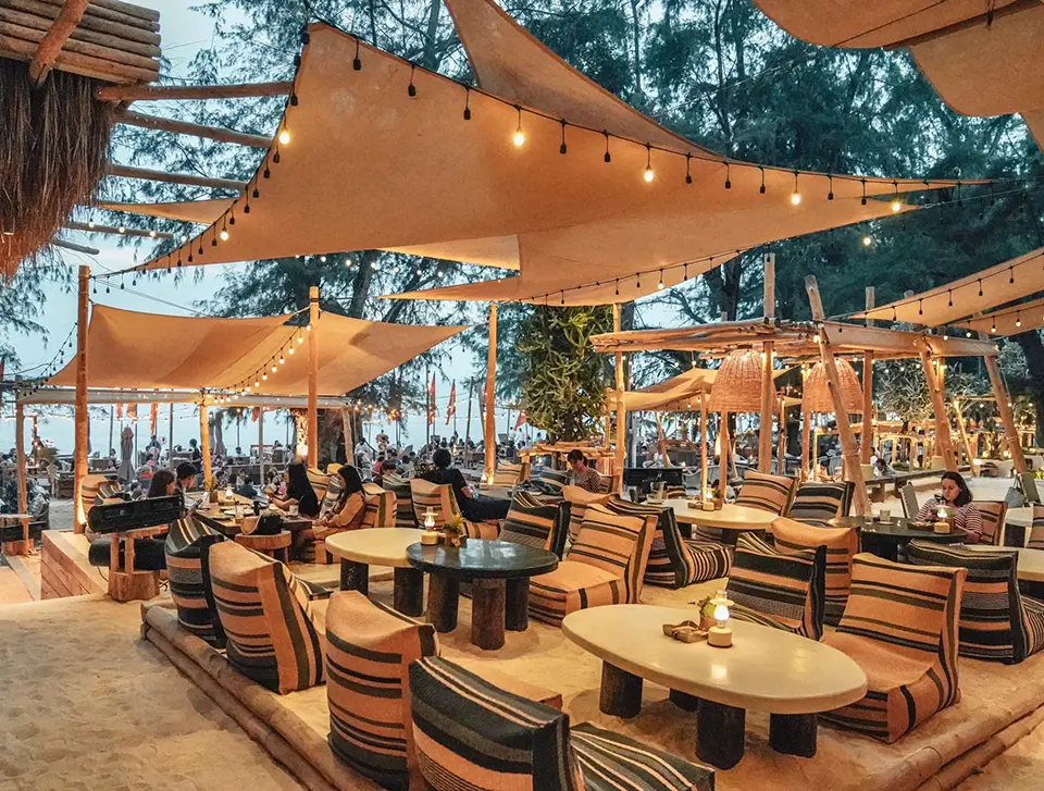 Boho-style beachfront restaurant with string lights and fabric canopies in Pattaya