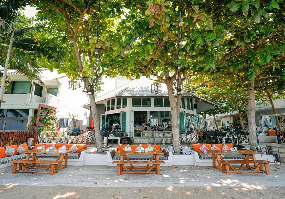 Outdoor seating area at Surf & Turf Beach Café in Pattaya with tropical shade trees