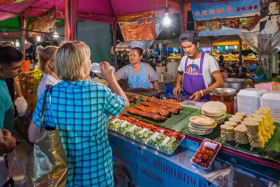 Street food vendor serving grilled prawns and squid in Pattaya