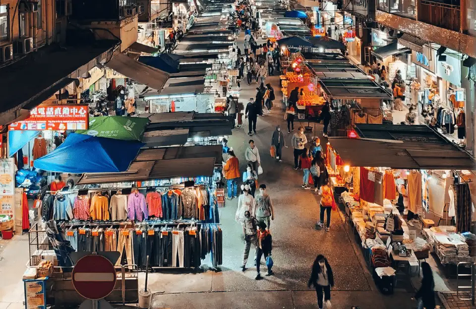 Bird's eye view of a popular Pattaya Thepprasit night market featuring neat rows of covered stalls selling clothing and accessories with locals and tourists shopping in the evening
