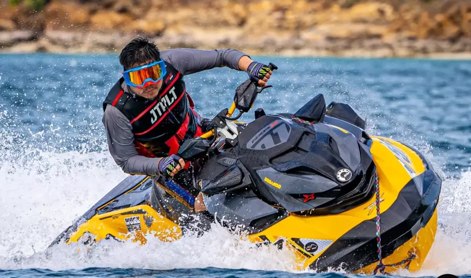 Thrilling jet ski adventure with rider in protective gear making dynamic turns in crystal blue waters