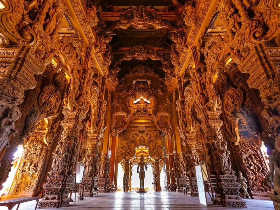 Breathtaking interior hall of the Sanctuary of Truth in Pattaya, featuring elaborate wooden carvings covering every surface from floor to ceiling