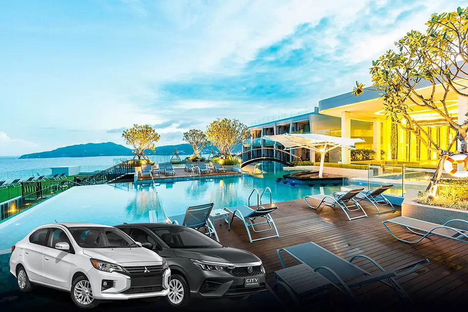 Two modern sedans - a white Mitsubishi and dark gray Honda - positioned in front of a spectacular luxury resort featuring an infinity pool overlooking the ocean. The contemporary beachfront hotel showcases modern architecture with expansive glass windows, elegant pool decking, and tropical landscaping, set against distant mountains and blue skies, representing the high-end destinations accessible through premium private transfer services in Phuket.