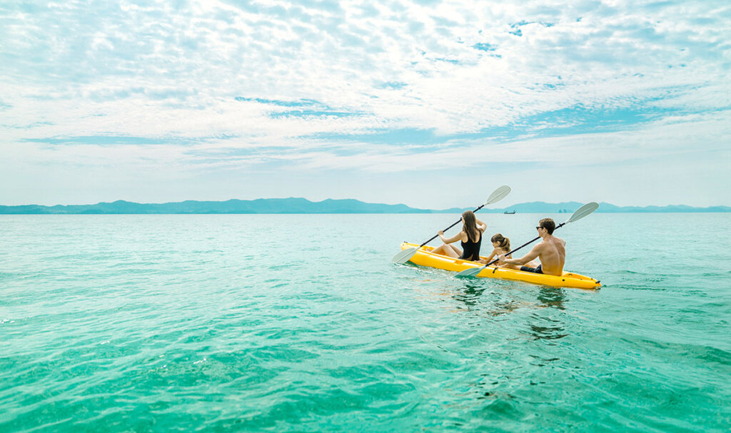 Phuket Family Trip: Parents and child sharing a peaceful kayaking moment in Phuket's pristine tropical waters