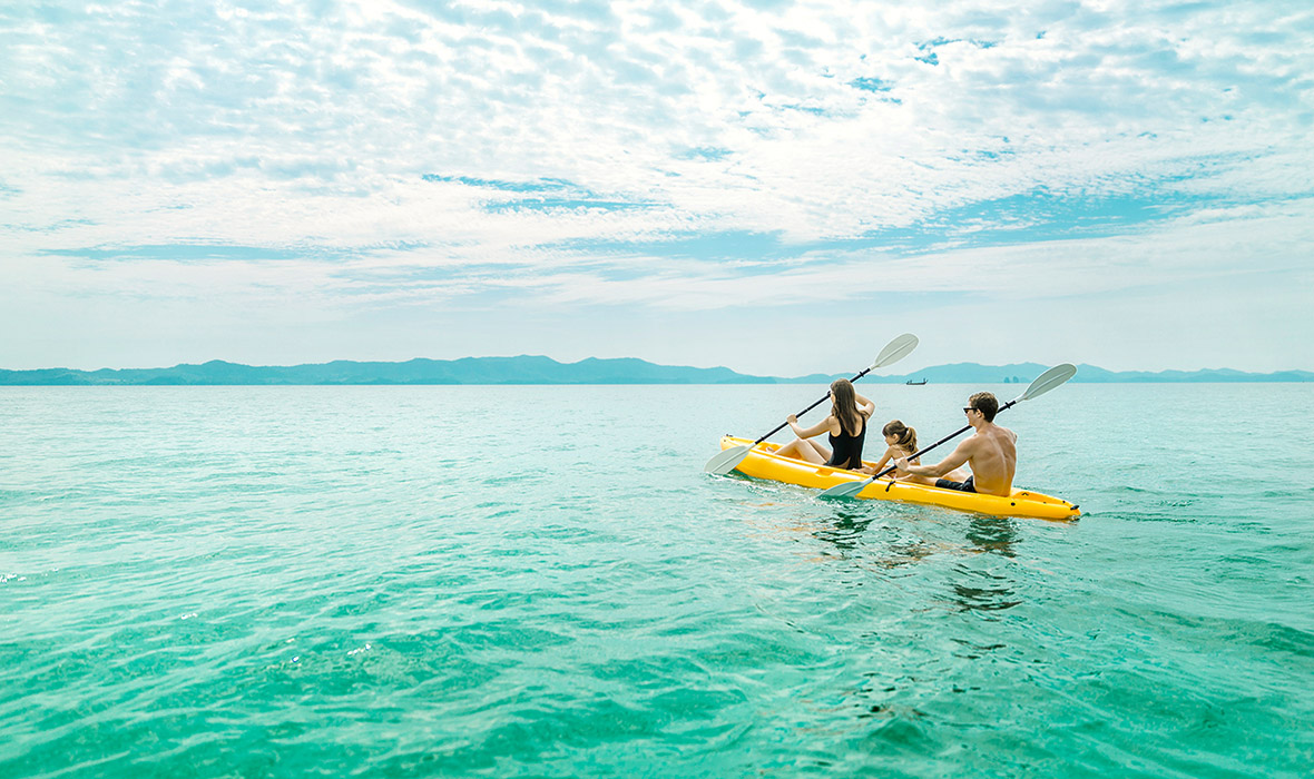 Phuket Family Trip: Parents and child sharing a peaceful kayaking moment in Phuket's pristine tropical waters