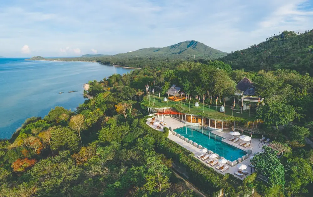 Kamalaya wellness resort's infinity pool and pavilions nestled in hillside jungle overlooking the ocean