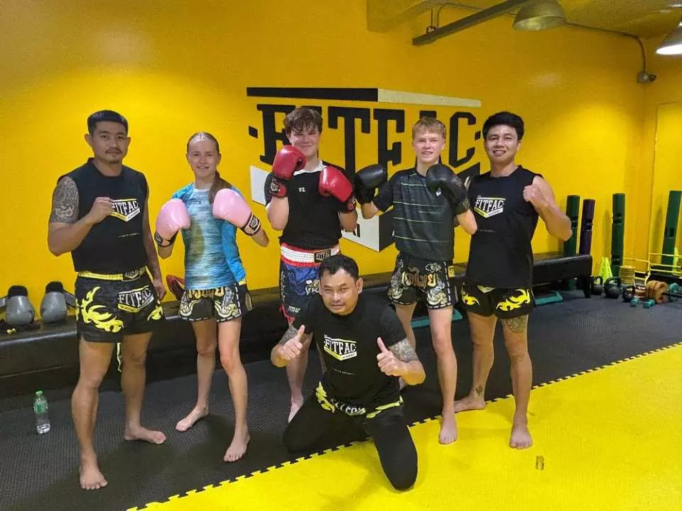 Thai boxing: Group of Muay Thai students posing with their instructor at FITFAC