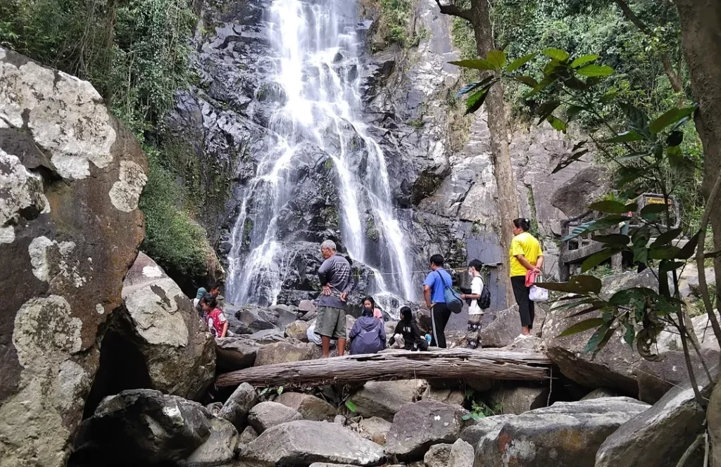Hidden Thailand: Visitors enjoying a waterfall surrounded by rocks and tropical forest in Nakhon Si Thammarat
