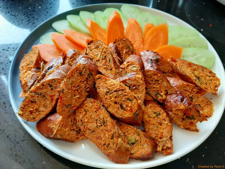 Thai Snacks: Sliced Northern Thai sausage with herbs and spices, served with fresh cucumber and carrot.